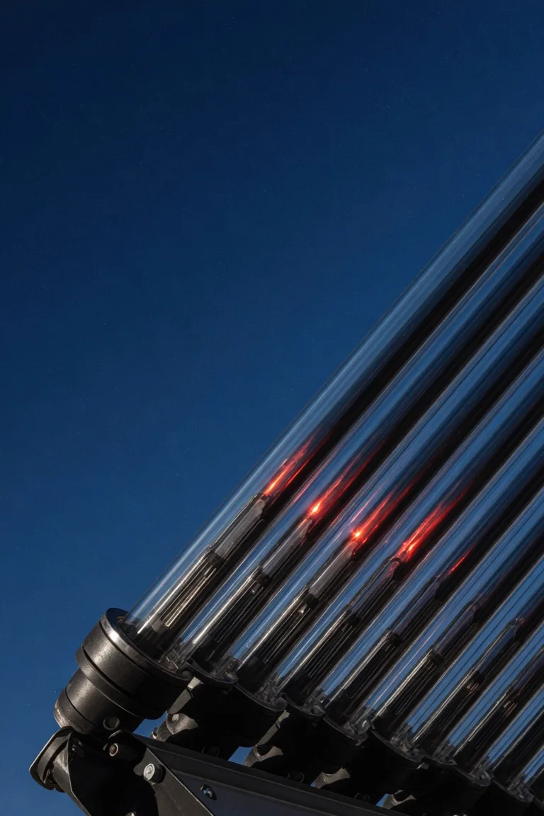 Vakuumröhren-Solarkollektor mit warmem Glühen gegen den Nachthimmel
